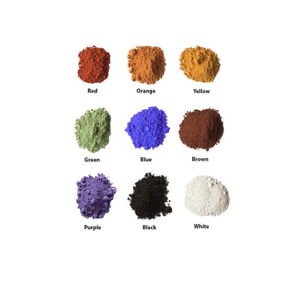 Samples, in small piles, of the nine colors of Natural Earth Paint; red, orange, yellow, green, blue, brown, purple, black and white