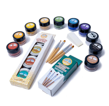 Components of the Deluxe Natural Face Paint &amp; Eco Glitter Set including ten colors of face paint, four colors of glitter, four makeup applicators and a makeup sponge