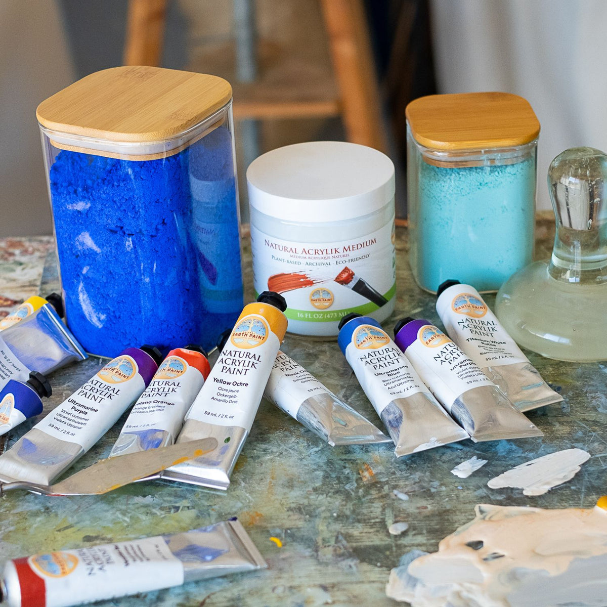 natural acrylik paint products pictured with jars of pigment on an artist&