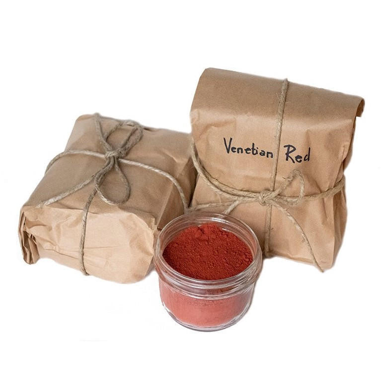 Two paper bags of Venetian Red pigment secured with twine next to an open jar of the same