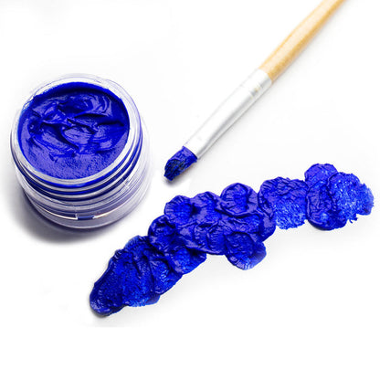 An open jar of blue face paint with brush and blue paint daubs on white paper
